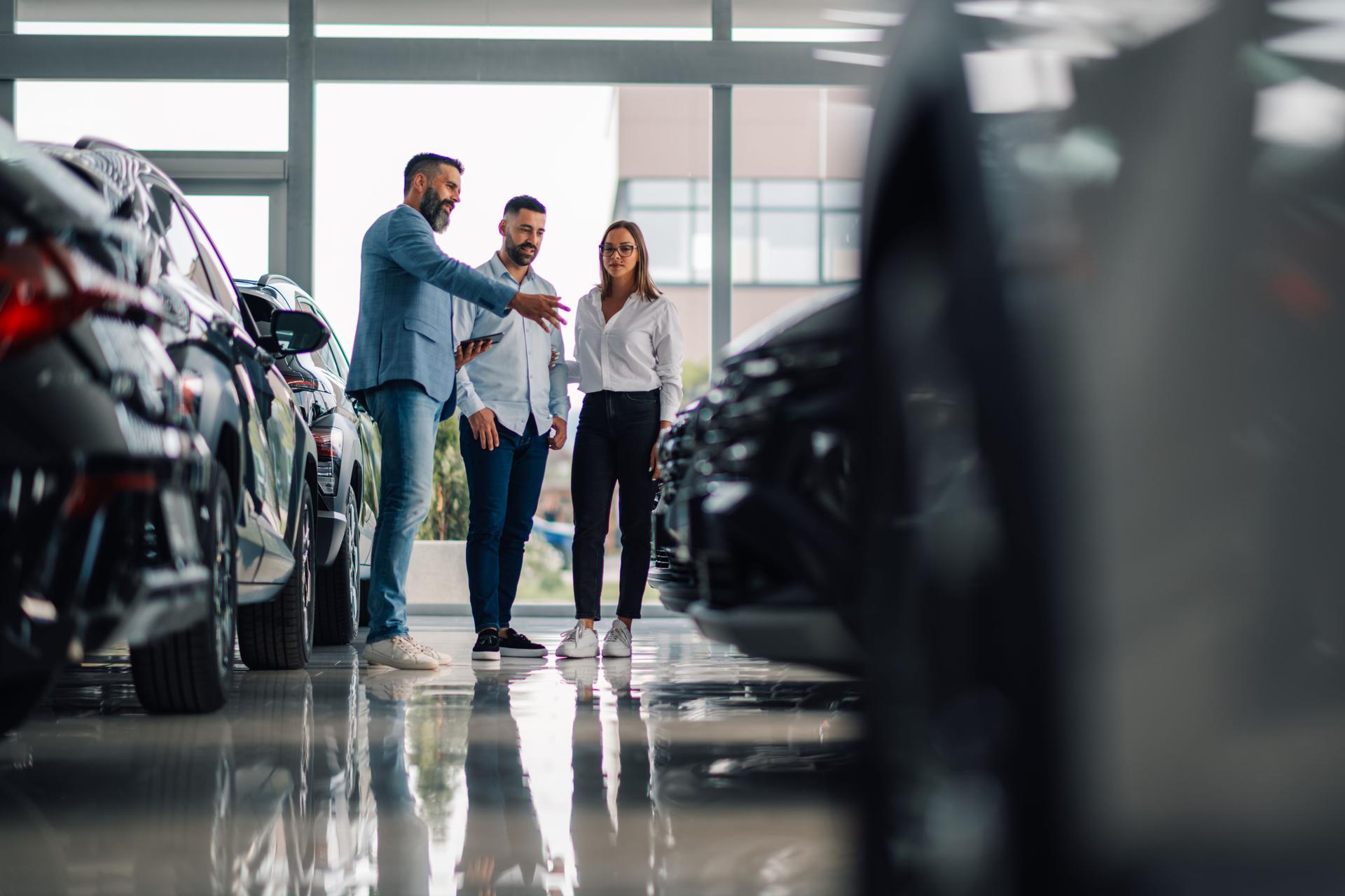 Car dealer passionately discussing car options with visitors.