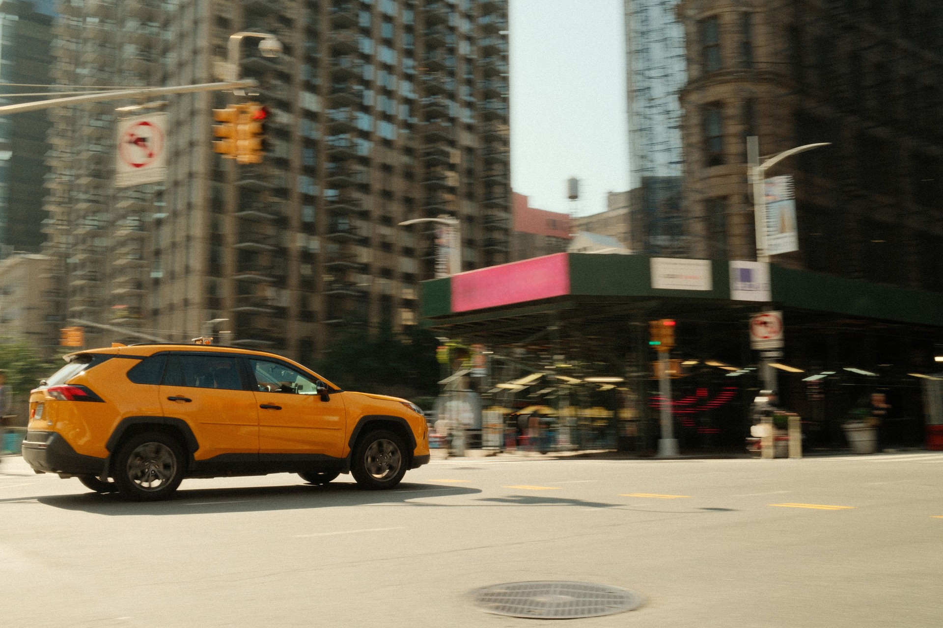 Yellow taxi cab driving through busy manhattan street in new york city